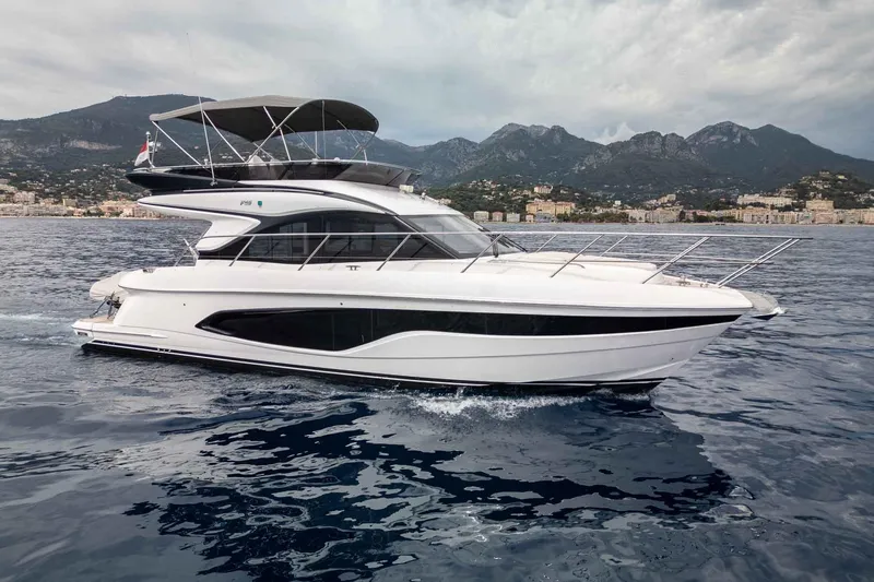  Yacht Photos Pics 2024 Princess F45 yacht cruising on open water with mountainous backdrop.