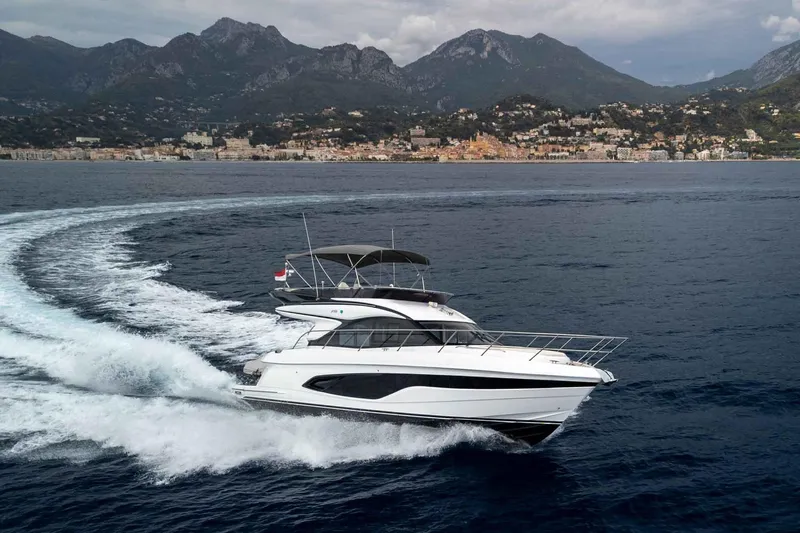  Yacht Photos Pics 2024 Princess F45 yacht cruising on open water with scenic mountain backdrop.