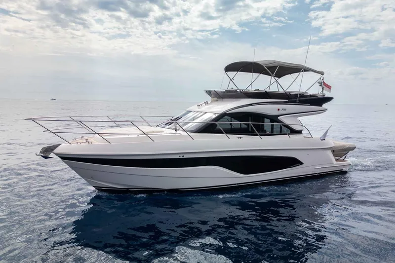  Yacht Photos Pics 2024 Princess F45 yacht cruising on calm ocean waters under a cloudy sky.