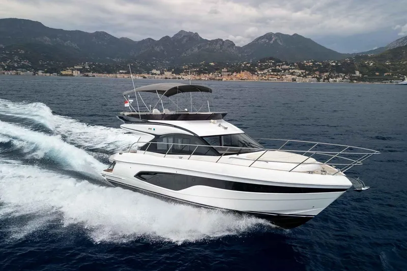  Yacht Photos Pics 2024 Princess F45 yacht cruising on the ocean with scenic mountain backdrop.
