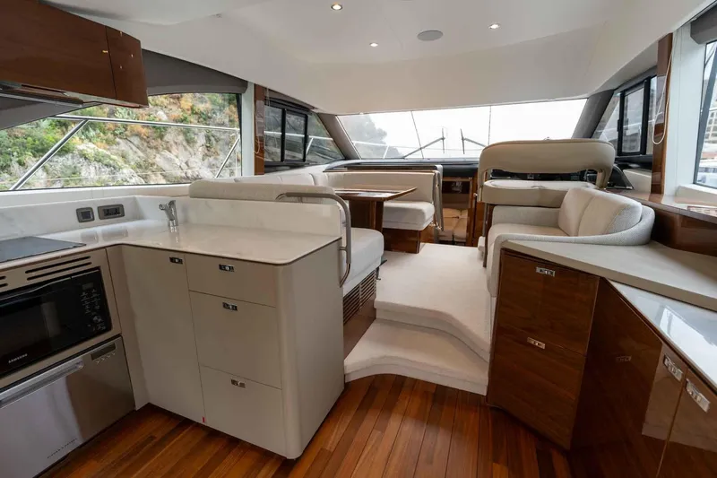  Yacht Photos Pics Luxurious interior of 2024 Princess F45 yacht with modern kitchen and seating area.