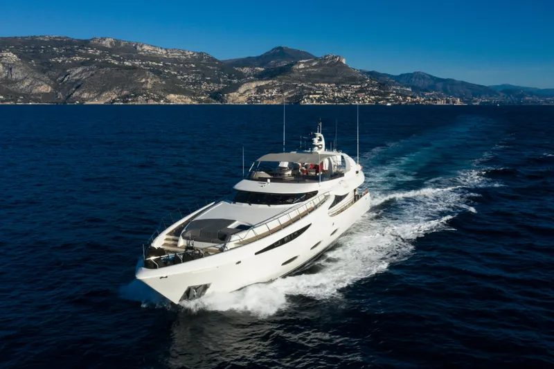 Viking III Yacht Photos Pics Luxurious Notika CENTURION 115 yacht cruising on blue ocean, mountainous coastline in background.