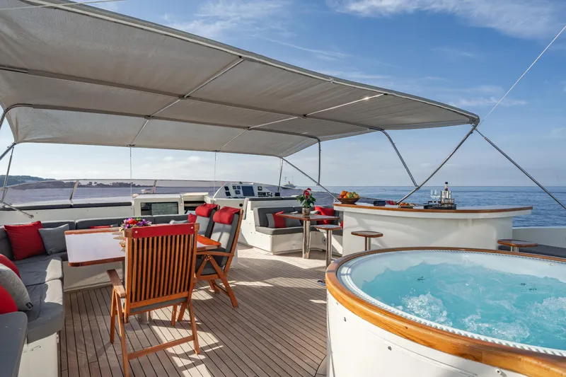 Viking III Yacht Photos Pics Luxurious Notika CENTURION 115 yacht deck with jacuzzi, dining area, and ocean view.