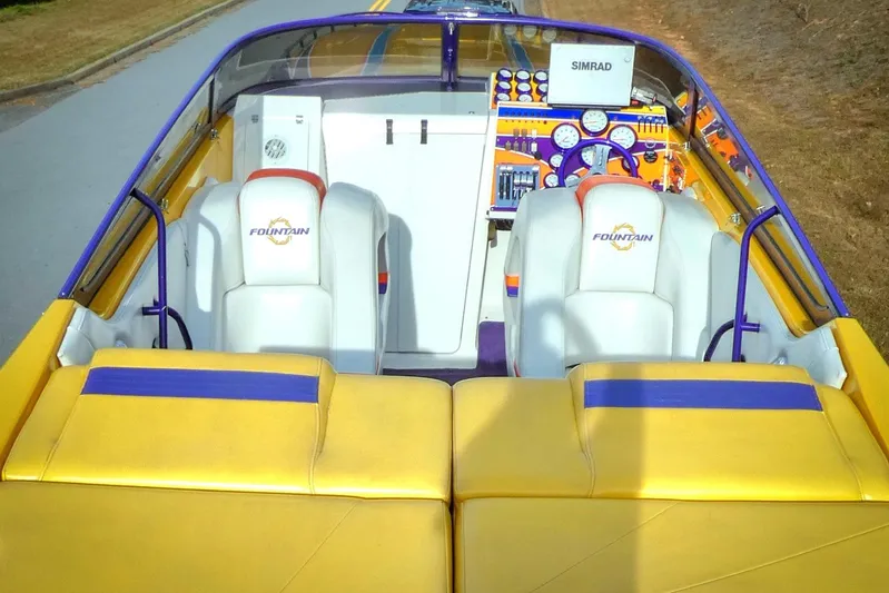  Yacht Photos Pics 2006 Fountain 47 Lightning boat interior with vibrant yellow and purple seating and dashboard.