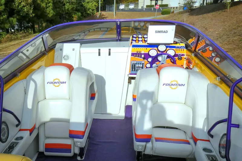  Yacht Photos Pics 2006 Fountain 47 Lightning boat interior with white seats and colorful dashboard.