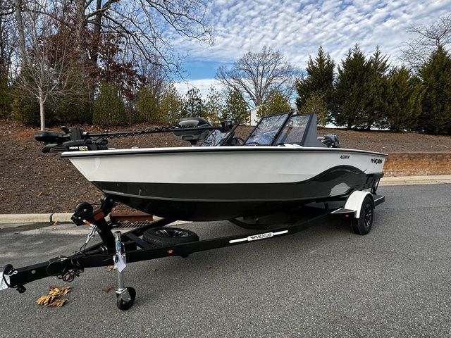 2024 Vexus ADX180 boat on trailer, parked outdoors with trees and cloudy sky background.