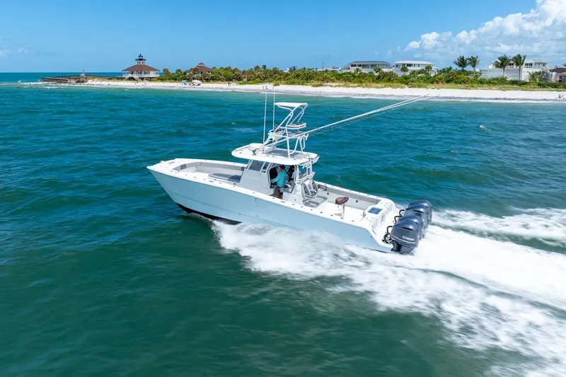  Yacht Photos Pics Freeman 37VH 2018 boat cruising near a scenic coastline under a clear blue sky.