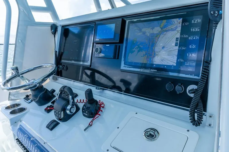  Yacht Photos Pics Control panel of a 2018 Freeman 37VH boat with navigation screens and steering wheel.