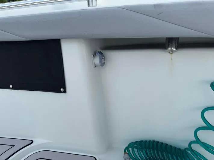  Yacht Photos Pics 2021 Yellowfin 26 Hybrid boat interior with coiled green hose and black panel.