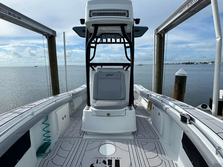  Yacht Photos Pics 2021 Yellowfin 26 Hybrid boat docked, showcasing spacious deck and seating.
