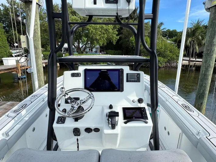  Yacht Photos Pics 2021 Yellowfin 26 Hybrid boat console with steering wheel and navigation screens.