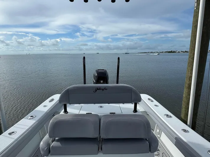  Yacht Photos Pics 2021 Yellowfin 26 Hybrid boat on calm water, showcasing rear seating and motor.