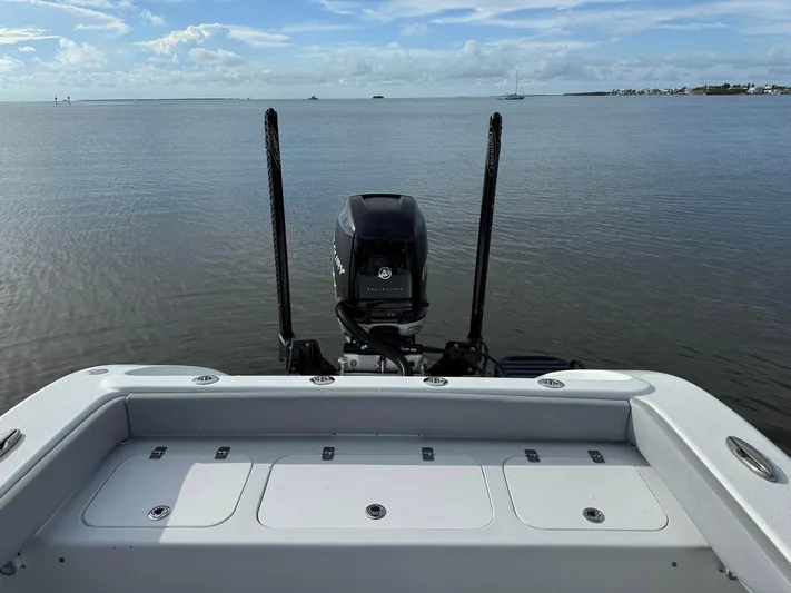  Yacht Photos Pics 2021 Yellowfin 26 Hybrid boat on calm water, featuring a powerful outboard motor.