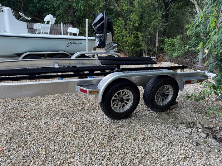  Yacht Photos Pics Trailer for 2021 Yellowfin 26 Hybrid boat on gravel driveway.