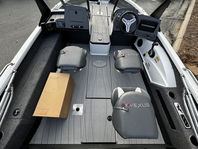 2024 Vexus ADX190 boat interior with seating, steering console, and a cardboard box on the floor.