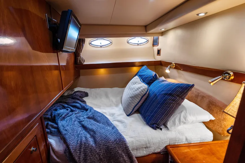 Trust Yacht Photos Pics Luxurious cabin interior of 2007 Meridian 490 Pilothouse yacht with cozy bedding and ambient lighting.