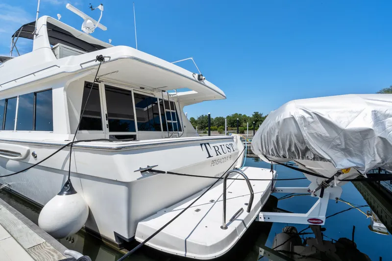 Trust Yacht Photos Pics 2007 Meridian 490 Pilothouse yacht docked with covered boat nearby.