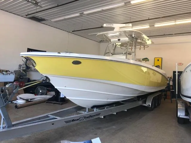  Yacht Photos Pics 2004 Boston Whaler 320 Outrage boat with yellow hull on trailer in garage.