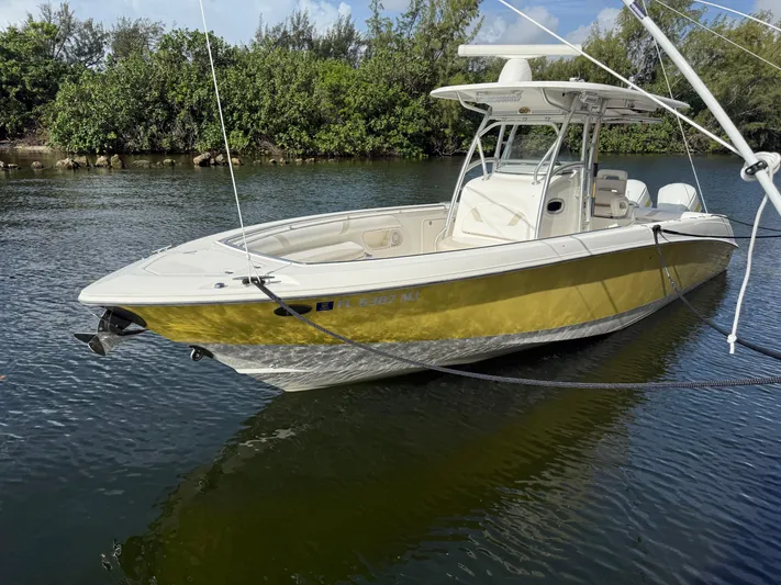  Yacht Photos Pics 2004 Boston Whaler 320 Outrage boat with yellow hull docked on calm water.