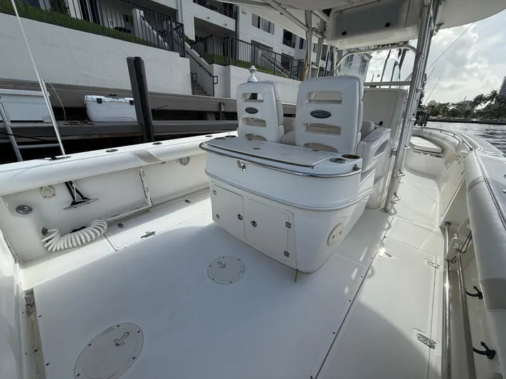  Yacht Photos Pics 2004 Boston Whaler 320 Outrage boat interior with seating and storage, docked near waterfront buildings.