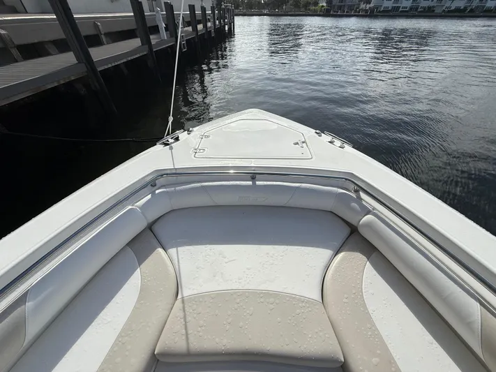  Yacht Photos Pics 2004 Boston Whaler 320 Outrage boat bow with seating, docked by the water.