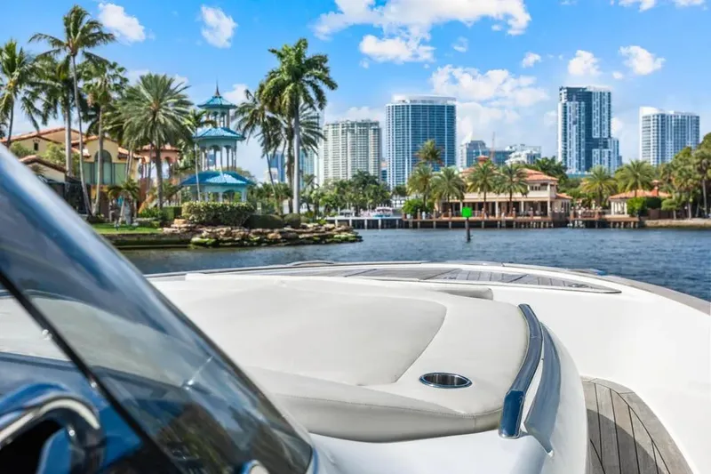  Yacht Photos Pics 2024 Solaris Power 44 Open yacht cruising near city skyline and palm trees.