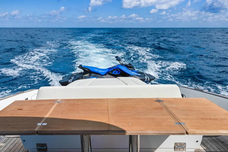  Yacht Photos Pics 2024 Solaris Power 44 Open yacht with jet ski on ocean, wooden table in foreground.