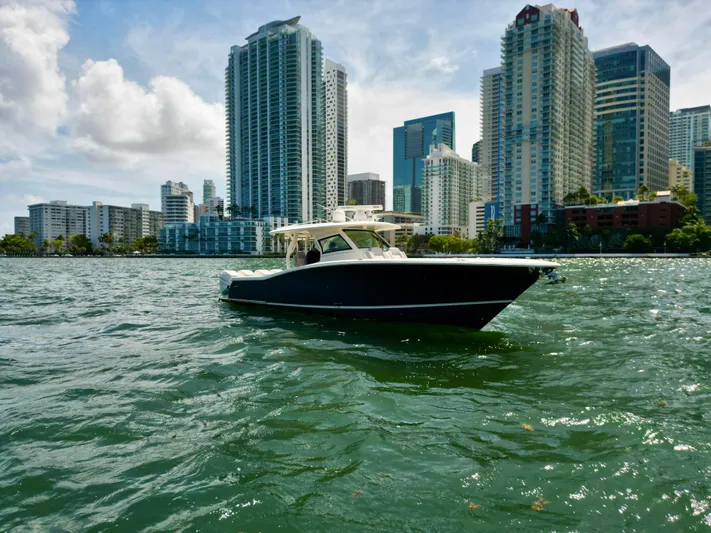  Yacht Photos Pics 2021 Scout 380 LXF boat on water with city skyline in background.