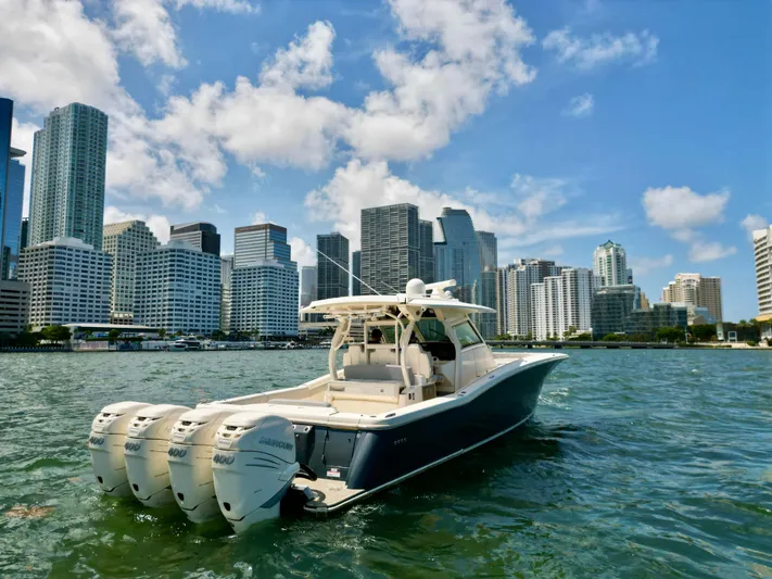  Yacht Photos Pics 2021 Scout 380 LXF boat on water with city skyline background.