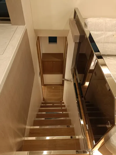  Yacht Photos Pics Interior staircase of 2022 Mazarin 55 Catamaran, featuring sleek wooden steps and modern design.