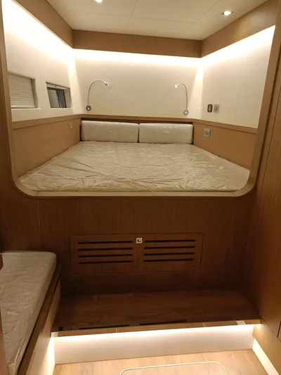  Yacht Photos Pics Luxurious bedroom interior of 2022 Mazarin 55 Catamaran, featuring modern lighting and wood finishes.