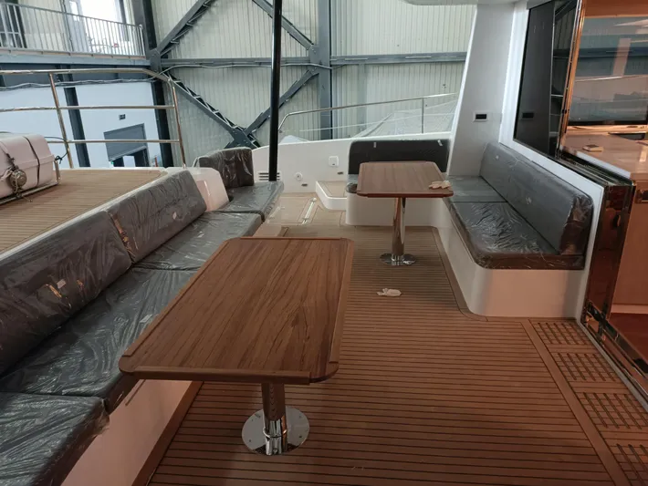  Yacht Photos Pics Mazarin 55 Catamaran 2022 interior with wooden tables and seating in a modern design.