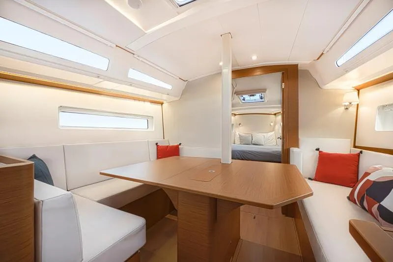  Yacht Photos Pics Luxurious interior of 2025 Jeanneau 380 sailboat with modern seating and dining area.