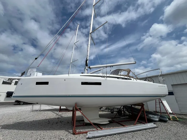  Yacht Photos Pics 2025 Jeanneau Sun Odyssey 380 sailboat on stands, under cloudy sky.
