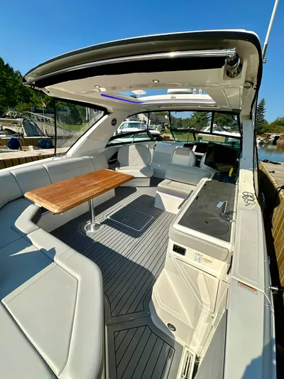  Yacht Photos Pics 2021 Sea Ray SLX 400 Outboard boat interior with seating and table, docked outdoors.