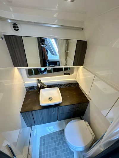  Yacht Photos Pics 2021 Sea Ray SLX 400 Outboard bathroom with modern sink, mirror, and toilet.
