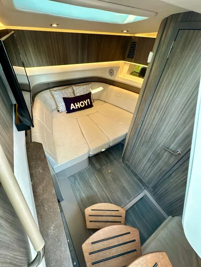  Yacht Photos Pics 2021 Sea Ray SLX 400 Outboard cabin interior with cozy bed and "Ahoy!" pillow.