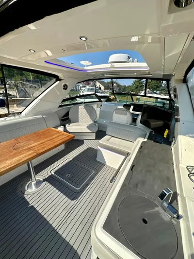 Yacht Photos Pics 2021 Sea Ray SLX 400 Outboard interior with seating, table, and helm in sunlight.