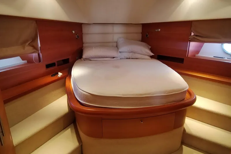  Yacht Photos Pics Luxurious cabin interior of 2007 Aicon 64 yacht with cozy bed and wooden accents.
