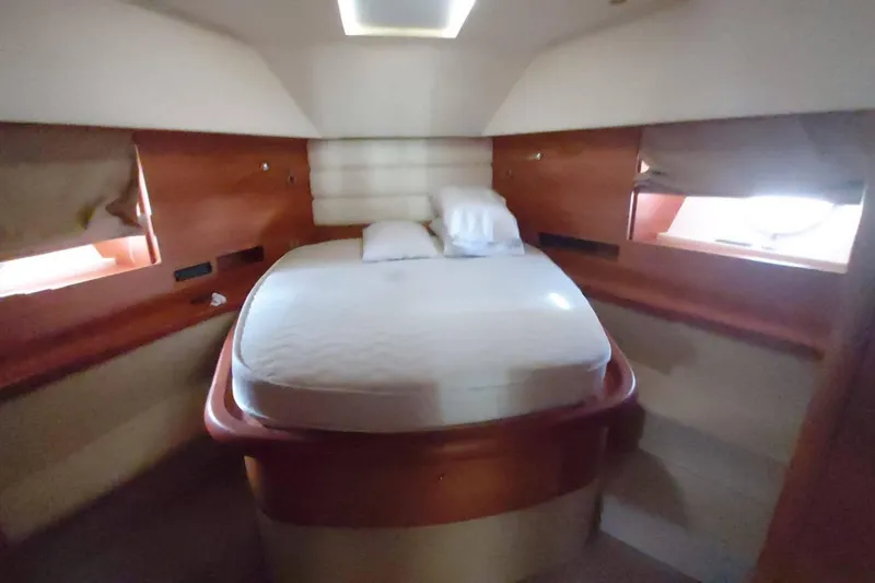  Yacht Photos Pics Luxurious cabin interior of 2007 Aicon 64 yacht with cozy bed and wooden accents.