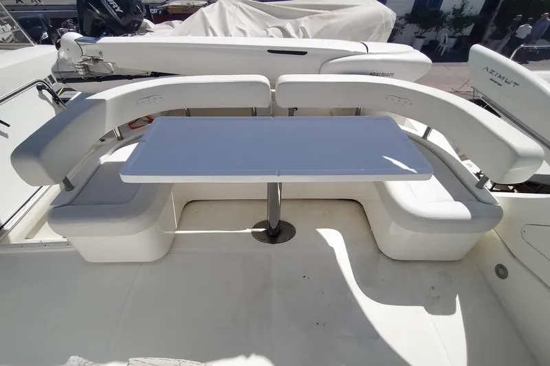  Yacht Photos Pics Luxury seating area on a 2007 Aicon 64 yacht with white table and cushioned benches.