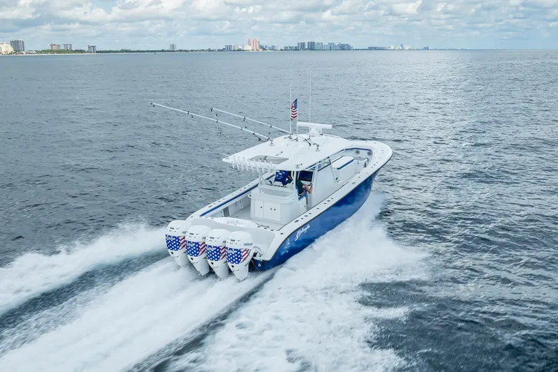  Yacht Photos Pics 2023 Yellowfin 39 Offshore boat cruising on open water with city skyline in background.