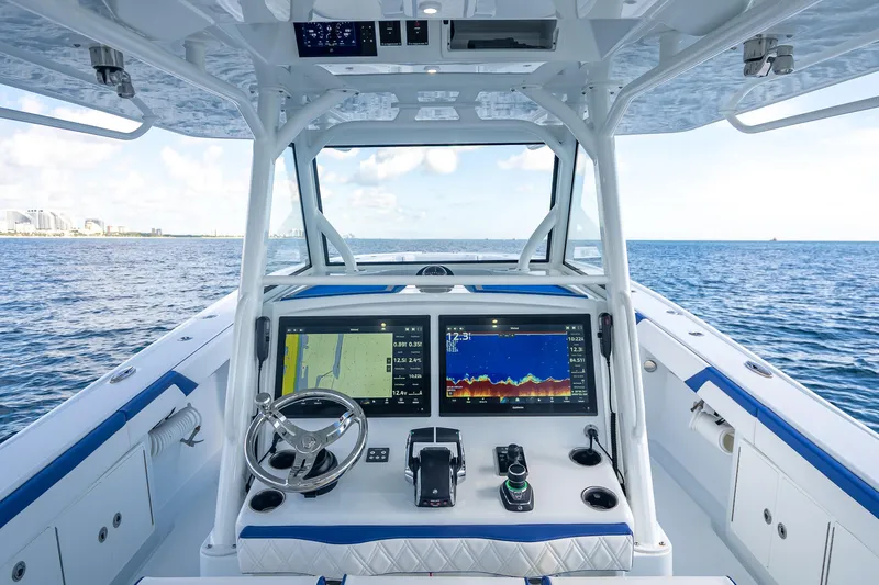  Yacht Photos Pics 2023 Yellowfin 39 Offshore boat dashboard with navigation screens on open sea.