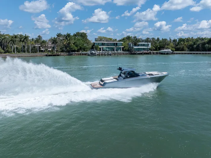 Pura Vida Yacht Photos Pics 2024 CNM CONTINENTAL 54 SuperSport cruising on a sunny day, surrounded by lush greenery.
