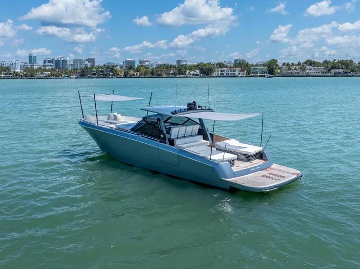 Pura Vida Yacht Photos Pics 2024 CNM CONTINENTAL 54 SuperSport yacht on calm water, city skyline in background.