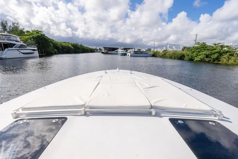 Prana Yacht Photos Pics Bow view of 1995 Itama 46 yacht on a serene waterway under cloudy skies.