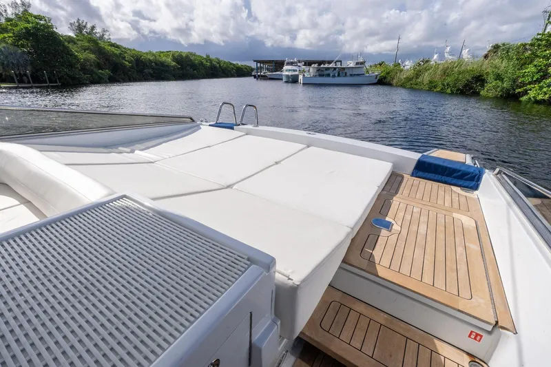 Prana Yacht Photos Pics 1995 Itama 46 yacht with spacious deck, moored on a serene river.