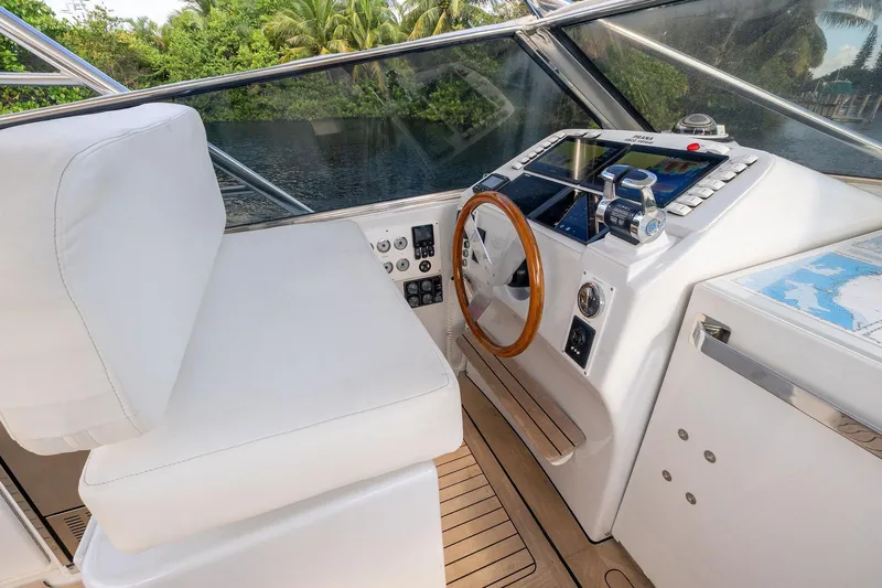 Prana Yacht Photos Pics Cockpit of a 1995 Itama 46 yacht with modern navigation equipment and wooden steering wheel.