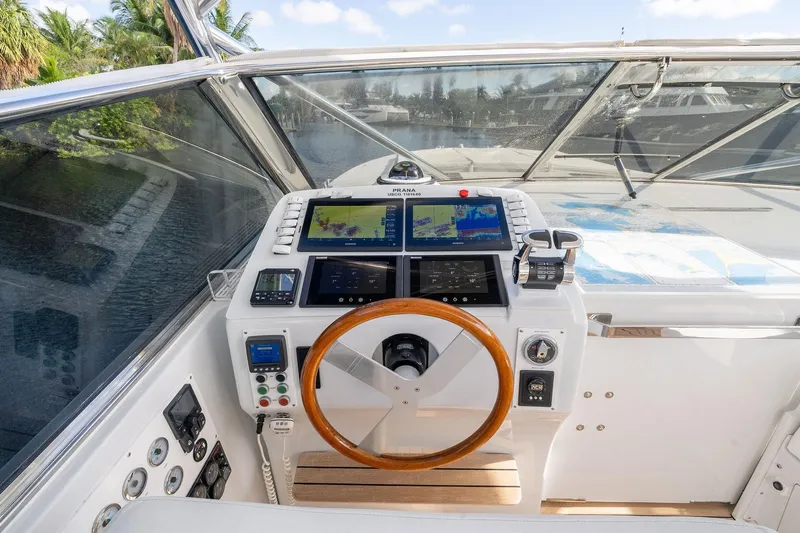 Prana Yacht Photos Pics Cockpit of 1995 Itama 46 yacht with navigation screens and wooden steering wheel.