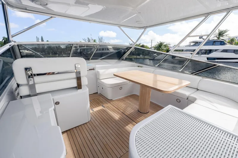 Prana Yacht Photos Pics Luxurious interior of a 1995 Itama 46 yacht with white seating and wooden table.